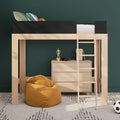 Space-saving light wood loft bed with ladder and built-in dresser, black guardrail, mustard bean bag, books and headphones against dark green accent wall