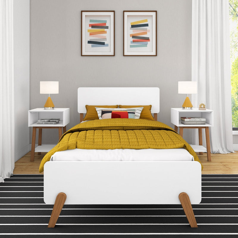 Mid-century modern bedroom with white platform bed on wooden legs, mustard yellow quilt and pillows, matching white nightstands with lamps, black-and-white striped rug, and abstract framed wall art