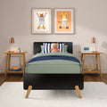 Modern kids bedroom with green bedding, striped pillow and plush rhino, wooden nightstands with copper lamps, toy camera and blue flip clock, plus two framed animal prints (bear on skateboard, tiger on scooter) — nursery wall art and children's room decor