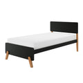 Modern single bed with black headboard and footboard, white mattress and angled wooden legs, minimalist Scandinavian-style bedroom furniture