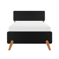 Minimalist mid-century modern black upholstered headboard with tapered oak legs and white mattress on a contemporary bed frame