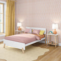 Modern kids bedroom with pink bedding, white wooden bed, yellow curtains, peach geometric wallpaper, bedside lamps and plush bunny toy