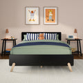 Modern kids bedroom nursery with green bedding, navy striped pillows, plush hippo toy, framed animal wall art and bedside lamps