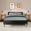 Modern kids bedroom nursery with green bedding, navy-striped pillows, plush hippo, wooden nightstands, copper lamps and framed tiger and bear wall art