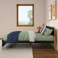 Modern kids bedroom with green bedding and navy throw, plush animal toy on wooden bedframe, natural wood window and framed animal prints