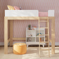 Wooden kids loft bed with white guardrail and ladder in pastel pink children's bedroom, patterned wallpaper, under-bed storage cubbies, toys and orange pouf