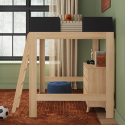 Wooden loft bed with ladder and built-in dresser in a modern kids bedroom with green walls, striped cushion and orange plush, blue pouf, soccer ball and large black-framed window