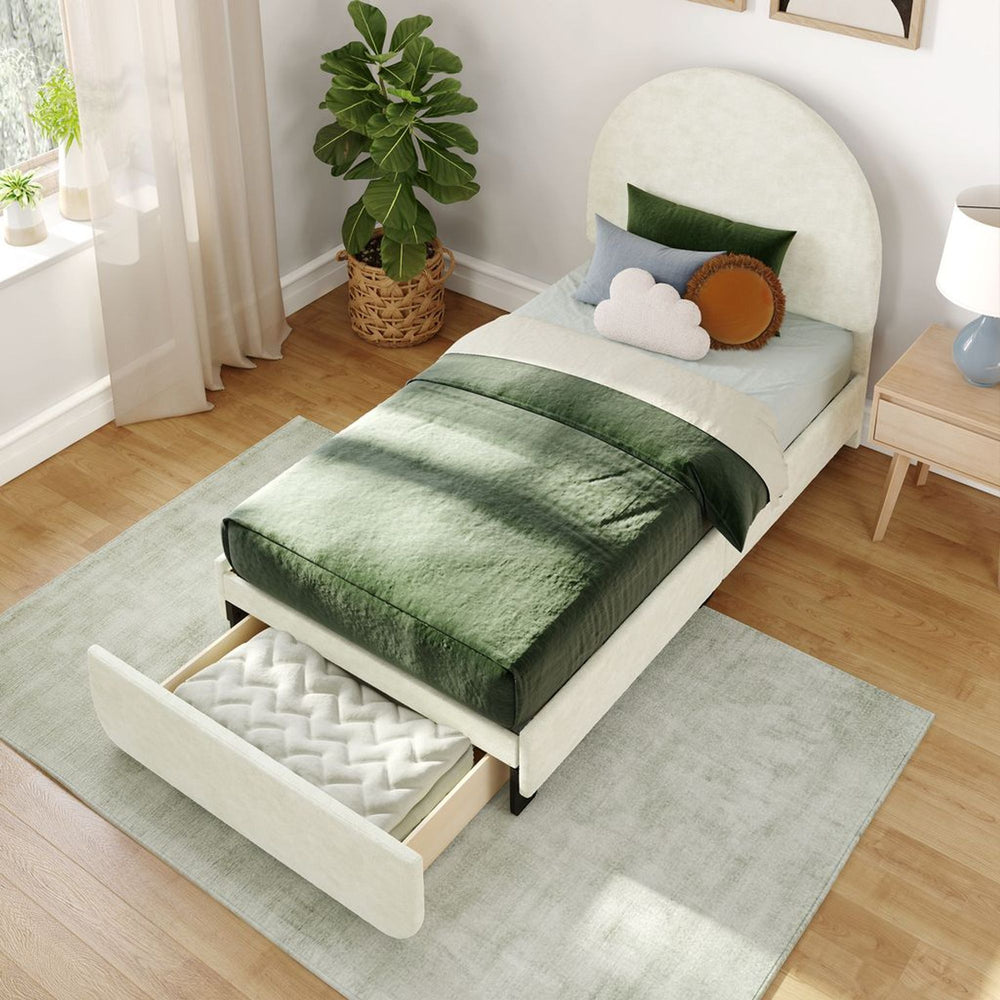 Single bed with green and white bedding set, featuring a pull-out storage drawer, set in a modern bedroom with wooden flooring and a potted plant.