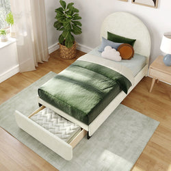 Single bed with green and white bedding set, featuring a pull-out storage drawer, set in a modern bedroom with wooden flooring and a potted plant.