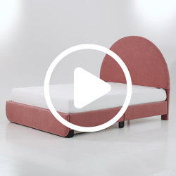Modern pink upholstered bed with arched headboard and white mattress.