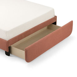 Rust-colored upholstered bed with white mattress and open storage drawer.