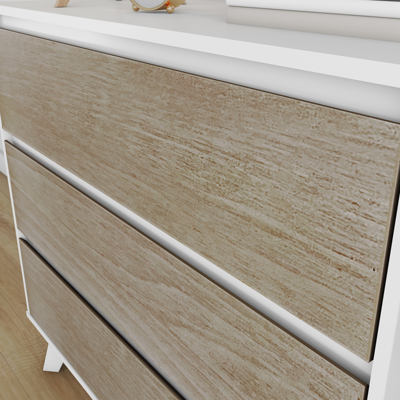 Close-up of a modern white-framed three-drawer chest with light oak textured wood-grain drawer fronts, minimalist bedroom dresser on hardwood floor