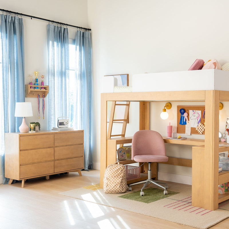 Bright children's bedroom with wooden loft bed and built-in desk, pink swivel chair, wooden dresser, blue curtains, backpack and trophy shelf