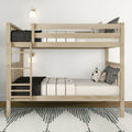 Natural wood bunk bed with ladder, black-and-white bedding and throw pillows, wall sconces and rug in a minimalist Scandinavian kids’ bedroom