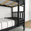 Black metal bunk bed frame with ladder and wooden slats, twin mattress with white striped sheets and charcoal knit blanket on hardwood floor with area rug