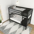 Modern black wooden bunk bed with ladder, monochrome grid bedding and decorative pillows under a wall sconce in a minimalist white bedroom with patterned rug and natural window light