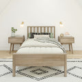 Minimalist Scandinavian bedroom with natural wood bed frame, matching nightstands, neutral bedding, patterned rug, wall sconces and green plant