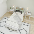 Modern minimalist Scandinavian bedroom with white wooden bed and slatted headboard, green pillows, matching nightstands, wall sconces, and black-and-white geometric rug