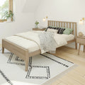 Minimalist Scandinavian bedroom with light wood platform bed, neutral bedding, green accent pillows, black-and-white geometric rug and bedside tables
