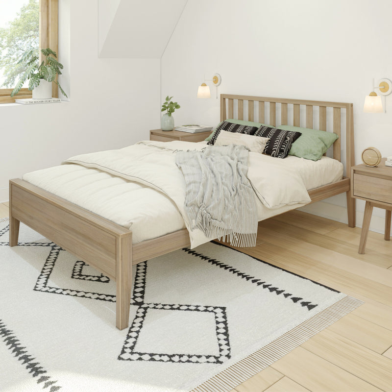 Minimalist Scandinavian bedroom with light wood platform bed, neutral bedding, green accent pillows, black-and-white geometric rug and bedside tables