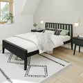 Modern minimalist bedroom with black platform bed, white bedding, patterned rug, bedside sconces, nightstands and potted window plant