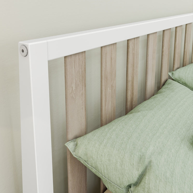 Wooden bed frame with white accents and green cushions in modern bedroom setting.