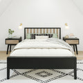 Minimal Scandinavian bedroom interior with black wood bed frame, white bedding, green and patterned pillows, matching nightstands, wall sconces, potted plant and geometric rug