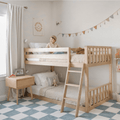 Smiling child on top of light wood kids bunk bed in neutral Scandinavian-style bedroom with ladder, bunting, stuffed animals and bedside table