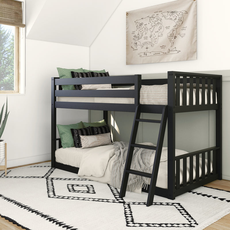 Black bunk bed with green and black pillows in modern bedroom setup.