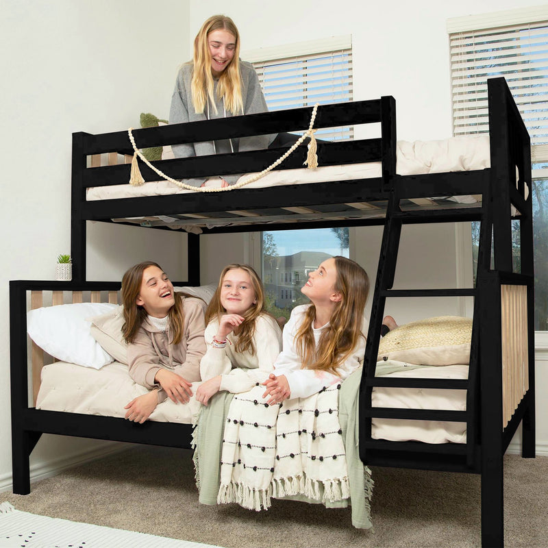 Three excited friends on a stylish black twin over twin bunk bed in a cozy bedroom setting.