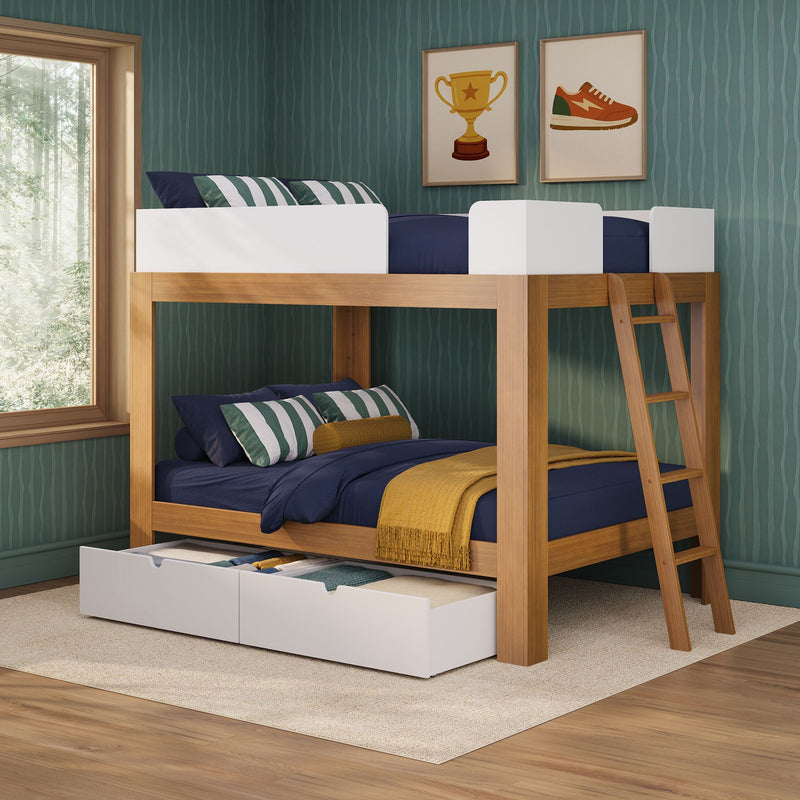 Modern wooden bunk bed with navy bedding, green striped pillows and under-bed storage drawers in a children's bedroom with teal textured wallpaper, ladder and framed trophy and sneaker prints beside a large window overlooking a forest.