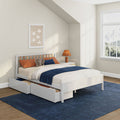 White wooden kids bed with under-bed storage drawers, navy throw blanket, orange pillows and stuffed elephant in bright modern nursery with star wall art and mountain-view window