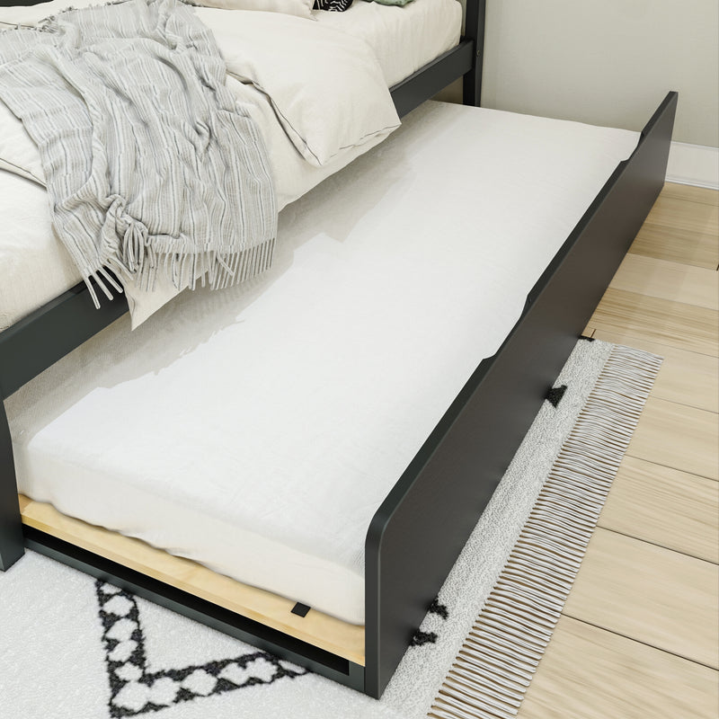 Pull-out trundle bed with white mattress and linens under dark wood frame, gray striped throw blanket on main bed in a modern bedroom with light wood floor and patterned rug