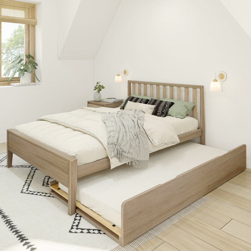 Wooden bed frame with pull-out trundle in a modern bedroom setting.