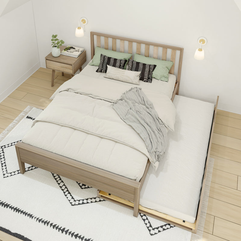 Scandinavian bedroom with wooden platform bed and trundle drawer, neutral bedding and textured throw, green accent pillows, nightstand with plant and wall sconces