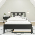 Minimalist bedroom with black wooden bed frame, white bedding, patterned pillows, nightstand with plant and wall sconces