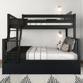 Black wooden bunk bed with full-size lower bed and twin upper bed, side ladder, white-and-black striped bedding, decorative pillows and wall sconces in a minimalist kids' bedroom