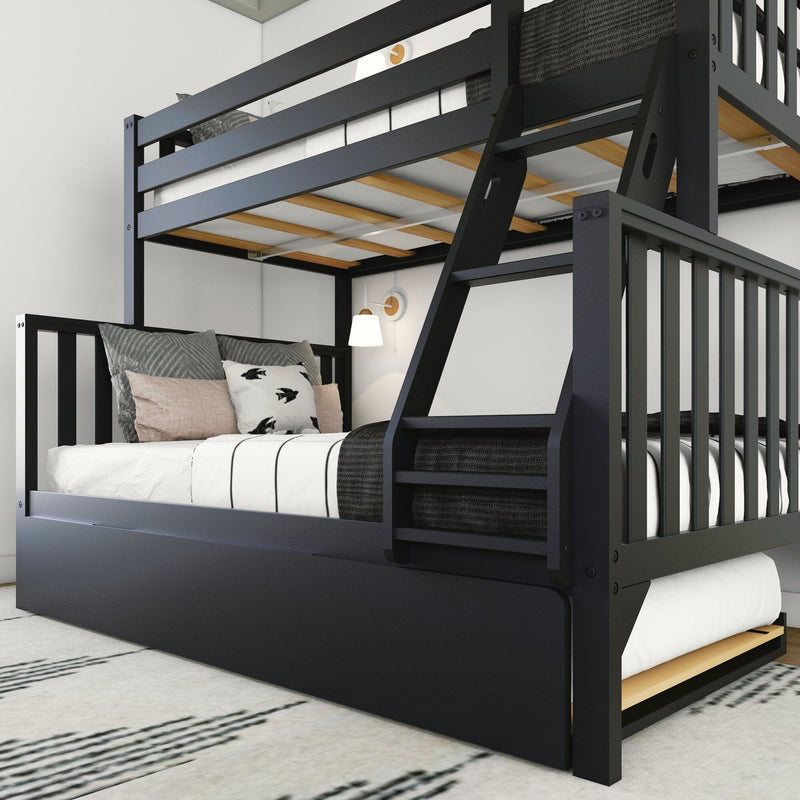 Space-saving black wooden twin-over-full bunk bed with angled ladder and pull-out trundle, white-and-black striped bedding and decorative pillows in a minimalist kids' bedroom