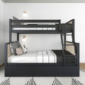 Modern black wooden twin-over-full bunk bed with ladder, white and black bedding, decorative pillows and wall sconces in a minimalist bedroom