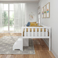 White wooden toddler bed with yellow bedding in bright children's bedroom featuring a star rug, large window, and playful wall art