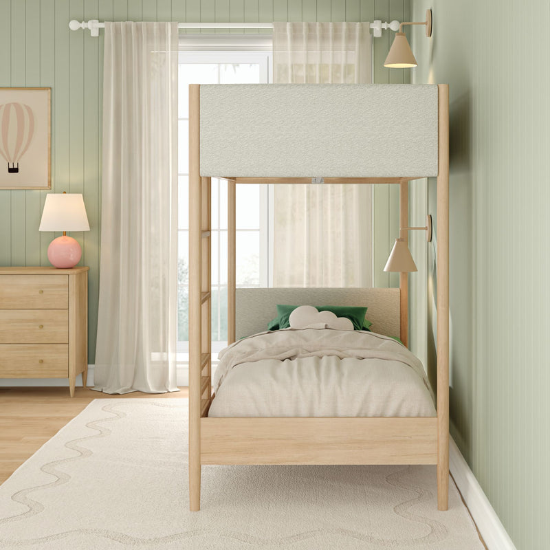 Minimalist kids bedroom with natural wood canopy bed, cream bedding and green accent pillows, pastel green beadboard walls, wooden dresser, pink lamp and sheer curtains, modern nursery decor and kids room design