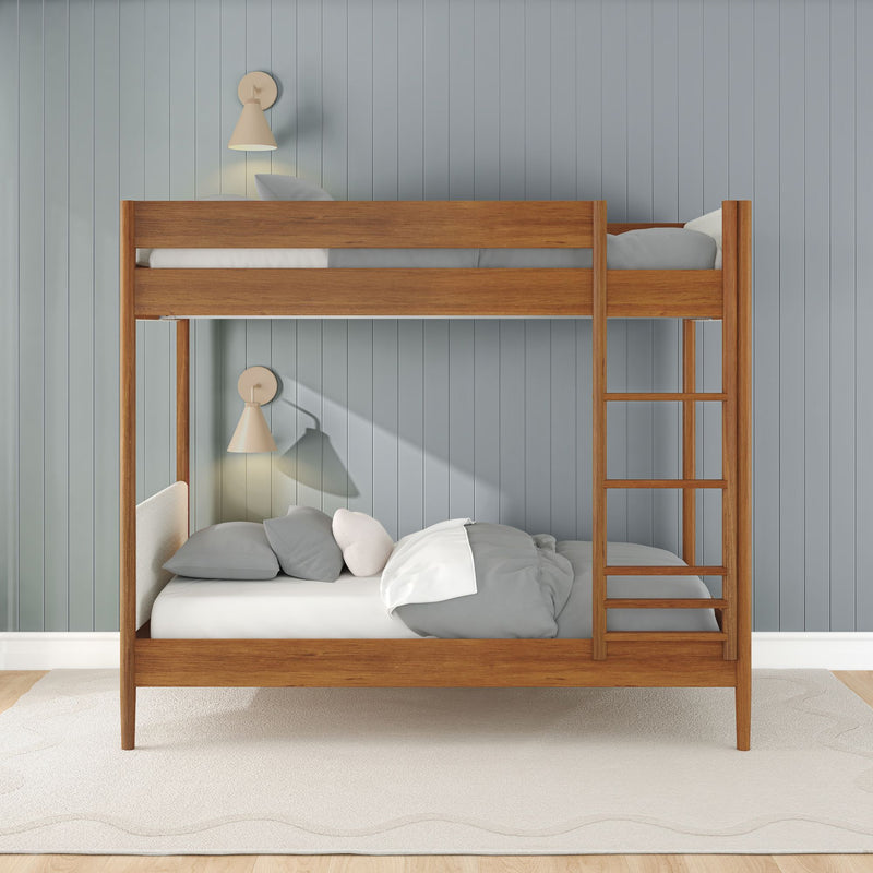 Modern wooden bunk bed with ladder in children's bedroom, gray paneled wall, neutral bedding, wall sconces and light wood floor