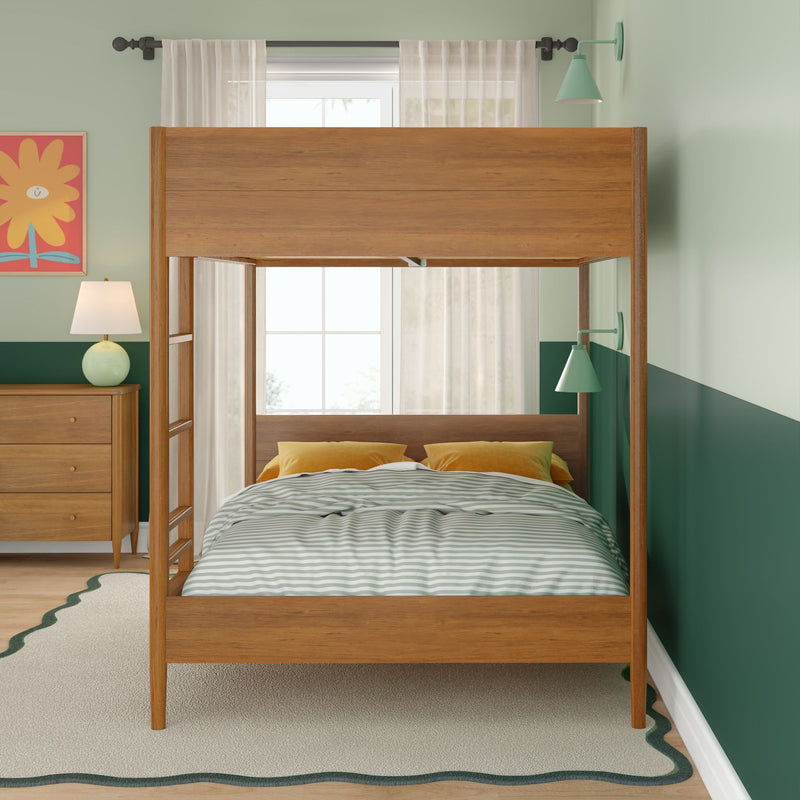 Modern wooden canopy bed in a mint and forest green children's bedroom with striped duvet, mustard pillows, mid-century dresser, bedside lamp, wall sconces and sheer window curtains