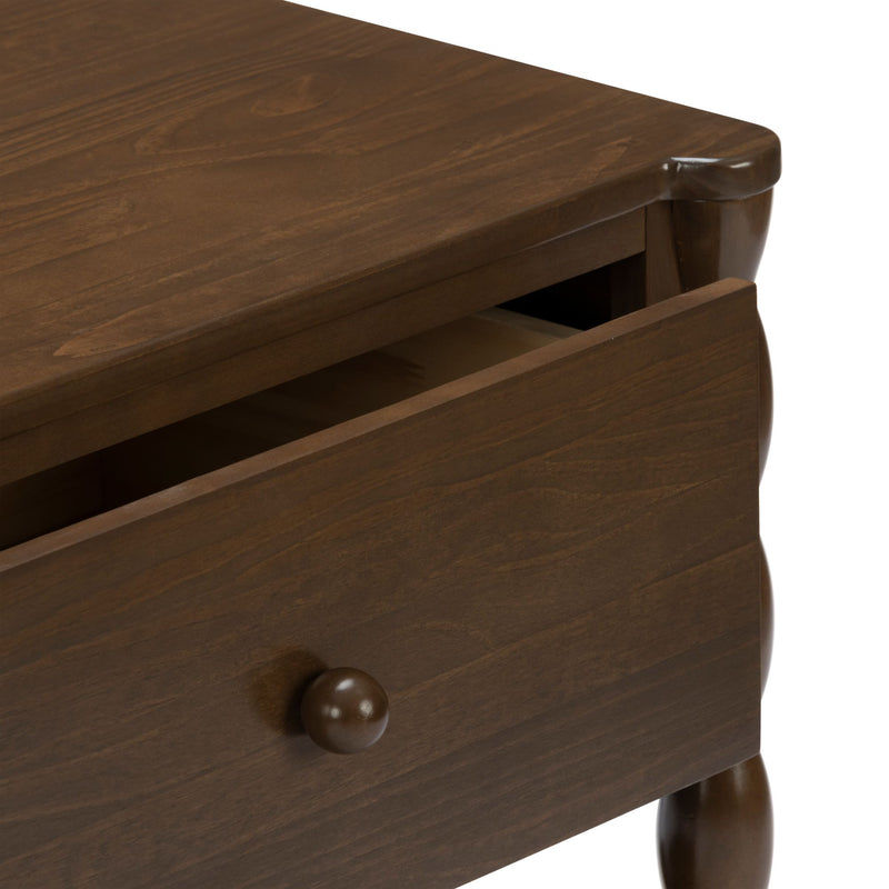 Close-up of dark walnut wooden nightstand drawer with round knob and turned leg, brown wood grain finish