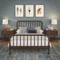 Nautical-inspired bedroom with dark wood spindle bed, white bedding and blue throw pillows, matching wooden nightstands with brass lamps, framed fishing artwork, plush whale toy and blue plaid area rug