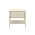 Cream wooden nightstand with single drawer and lower shelf, turned spindle legs, farmhouse bedside table on white background