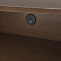 Modern round recessed wall outlet with AC socket and USB-A and USB-C charging ports installed in dark wood baseboard for bedside charging