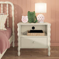 Kids white nightstand with pink heart lamp, green stuffed frog, pink alarm clock and wicker basket holding a charging tablet in blush bedroom.