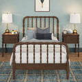 Children's bedroom with wooden spindle bed, blue accent wall, matching bedside tables and brass table lamps, plush toys, alarm clock and decorative pillows