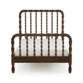 Dark walnut solid wood spindle bed frame with turned spindles on headboard and footboard and a white mattress on a clean white background